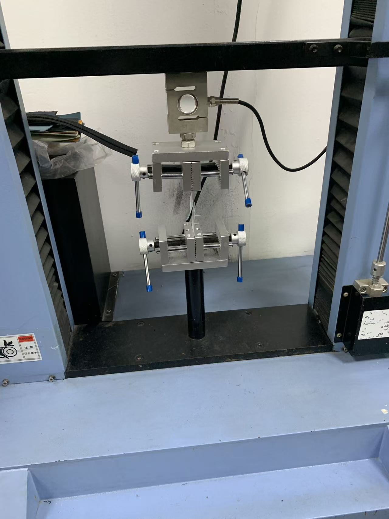 Load cell and opposing grips holding a specimen